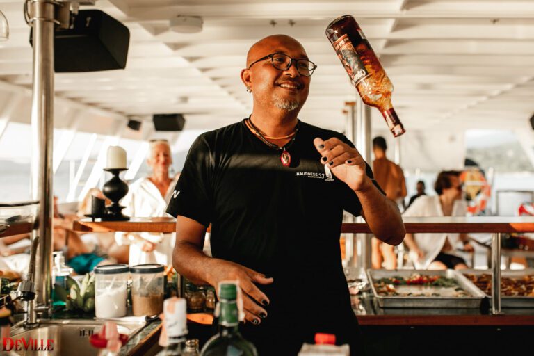 A bartender on a party boat flipping a bottle